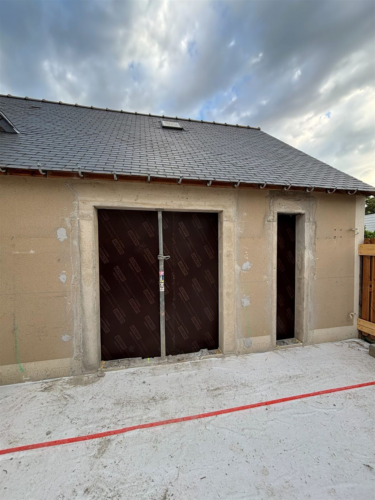 Rénovation extérieure d'un bâtiment en pierre par CHAML KVM — toiture neuve et façade enduite