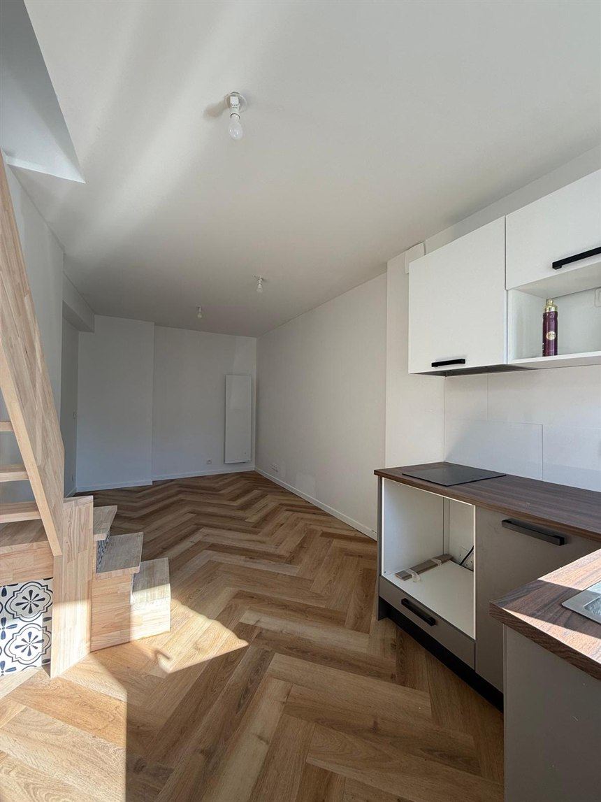 Salon fini avec cuisine et parquet après travaux