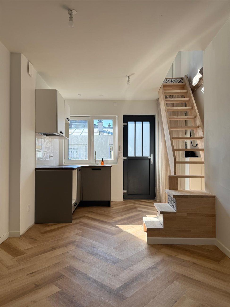 Pièce de vie avec escalier bois et parquet chevron, rénovation Nozay